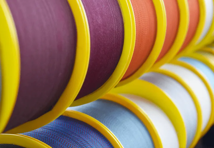 Industrial reels of multifilament PES cordage demonstrating colour variety for integrated interior blind systems