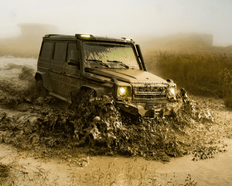 Dark 4x4 vehicle navigating through a deep, muddy puddle during an off-road recovery scenario