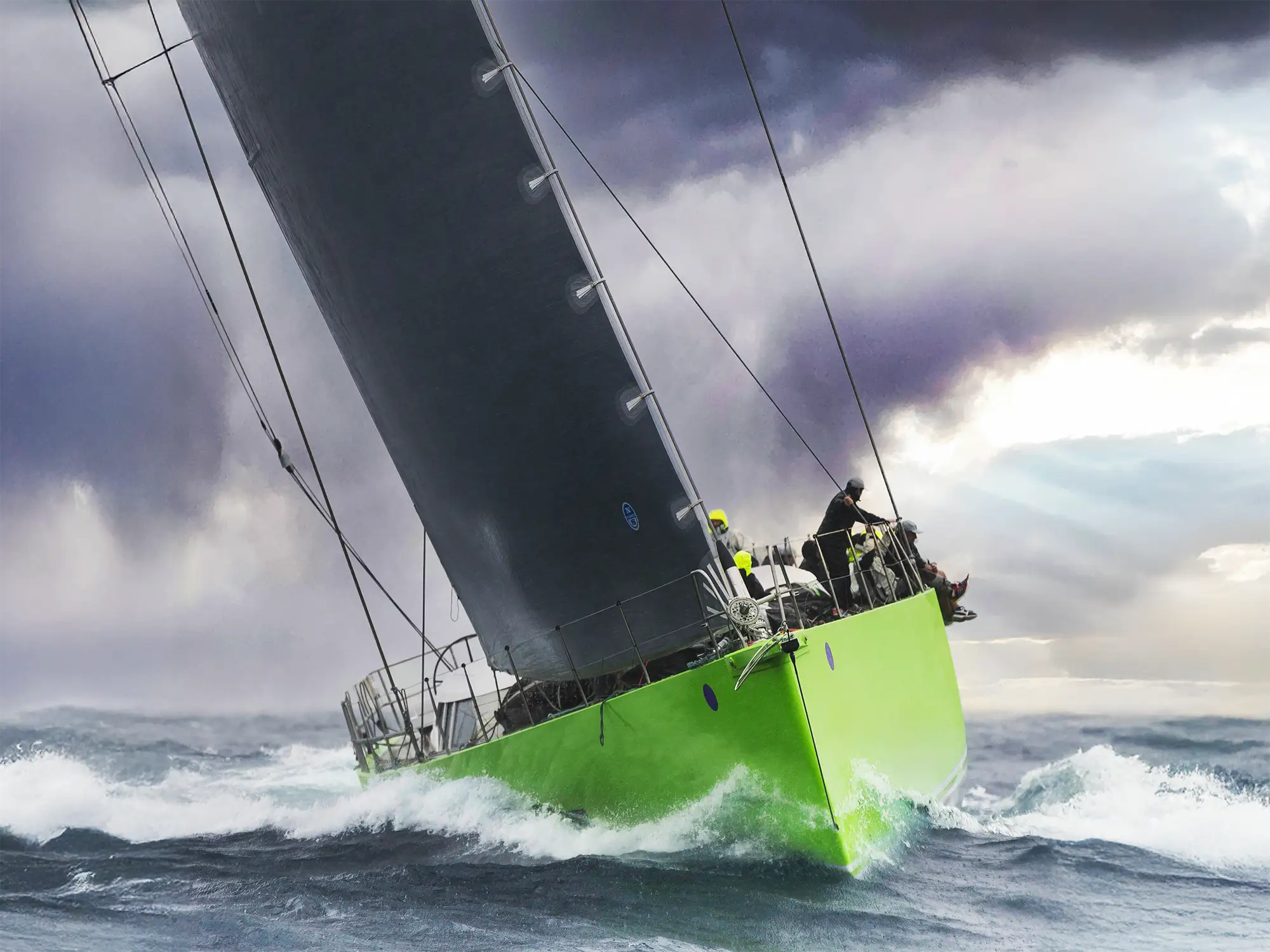 Grand prix racing yacht sailing heavily heeled in rough conditions, demonstrating high loads on performance rigging and halyards